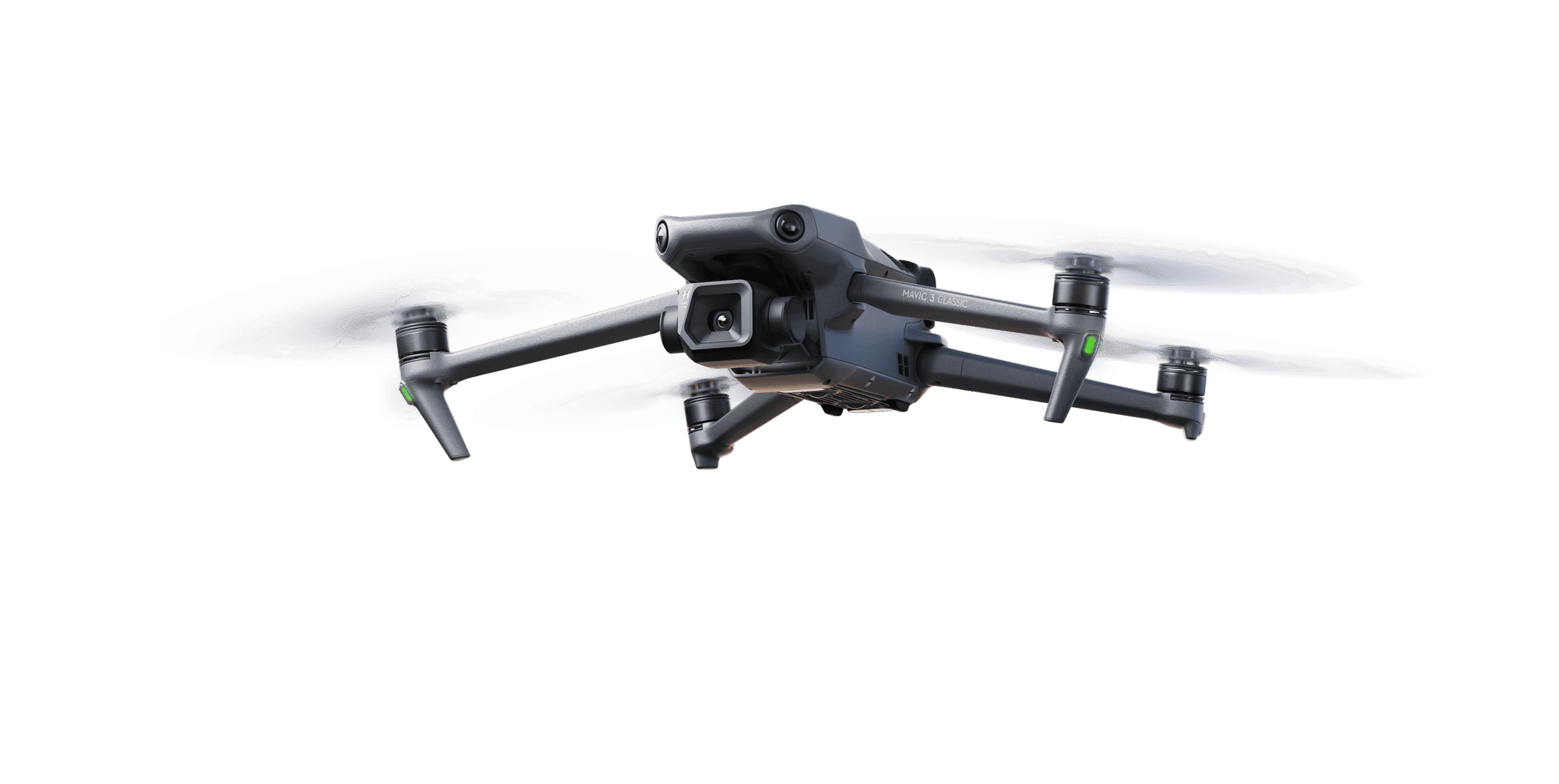 Un drone quadcopter nero con una telecamera montata sulla parte anteriore vola su uno sfondo bianco. Le eliche del drone girano e le luci di navigazione sui bracci sono illuminate di verde.