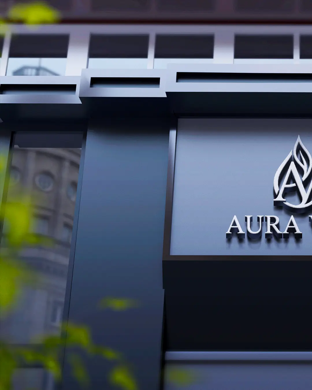 Facciata di un edificio moderno con un'insegna elegante e scura che mostra un logo a fiamma stilizzato e la parola "AURA" in lettere argentate. In primo piano è visibile una vegetazione sfocata, mentre in alto si trovano finestre riflettenti.