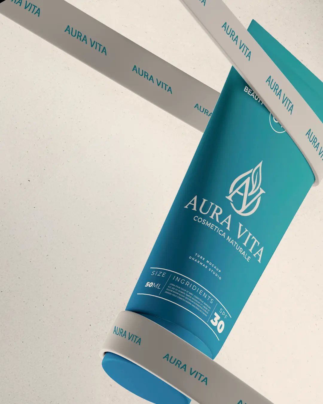 Un tubetto verde acqua di cosmetici naturali Aura Vita SPF 30 è sospeso in diagonale con nastri color crema su uno sfondo neutro. L'etichetta presenta un testo bianco e il logo di una foglia stilizzata.