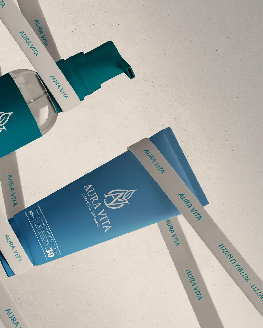 Due prodotti per la cura della pelle Aura Vita color verde acqua, un flacone a pompa e un tubetto con la dicitura SPF 30, sono avvolti in diagonale da nastri bianchi con la scritta AURA VITA su uno sfondo chiaro e strutturato.
