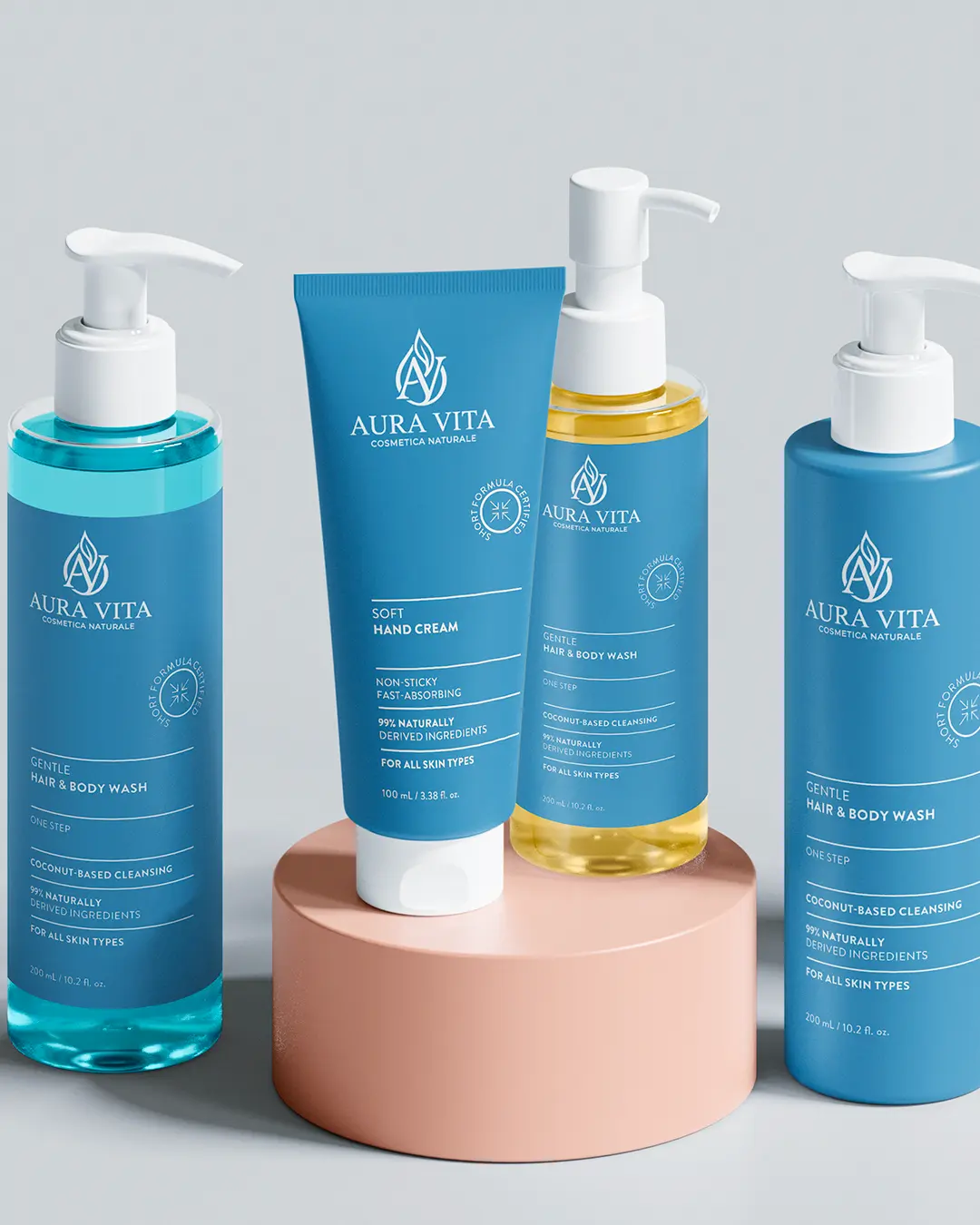 Quattro prodotti blu per la cura della pelle di Aura Vita, tra cui bottiglie con pompetta e un tubetto di crema per le mani, sono esposti su un piedistallo rotondo rosa su uno sfondo grigio chiaro.