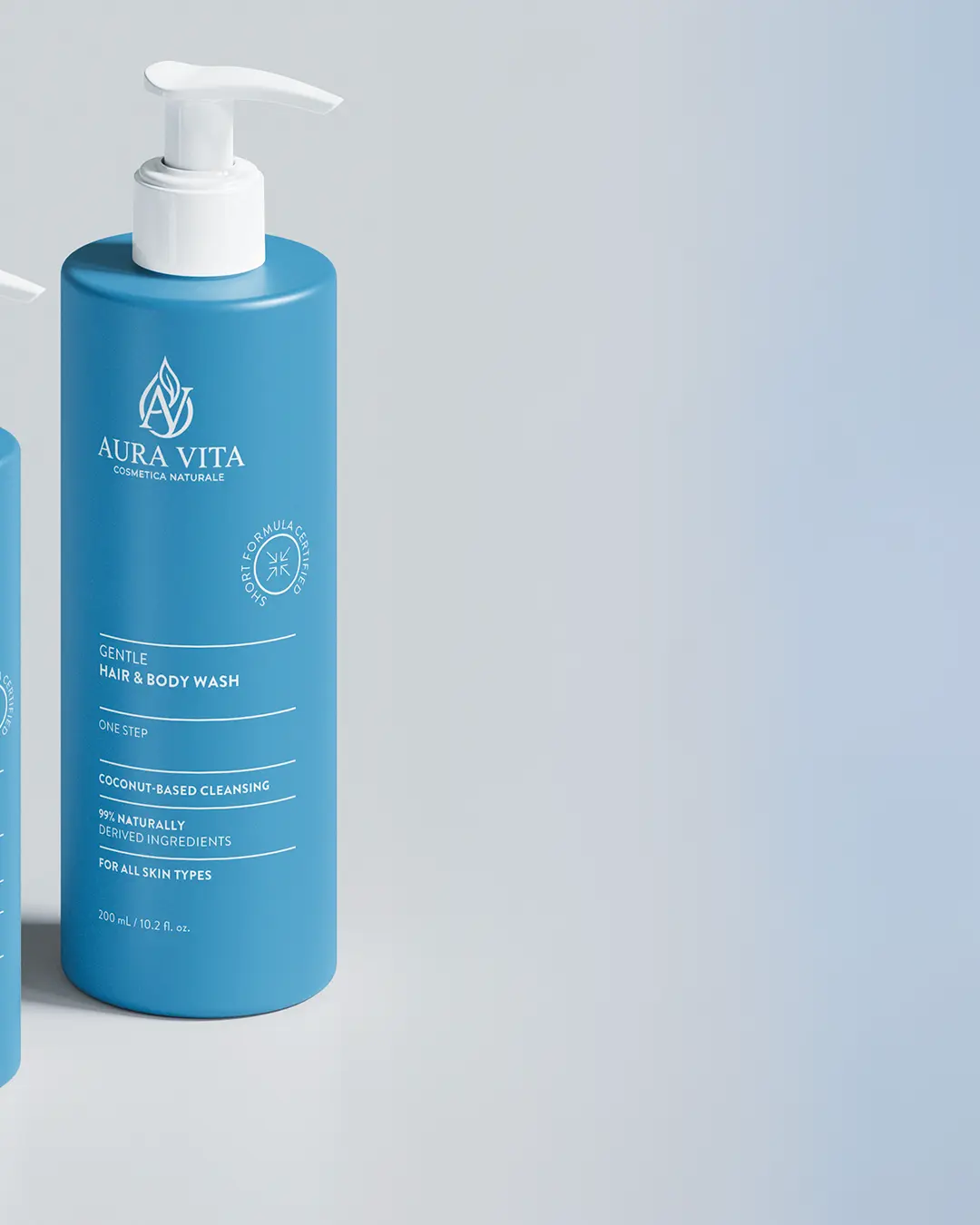 Due flaconi blu di Aura Vita Gentle Hair & Body Wash con erogatori a pompa bianchi su sfondo chiaro. Le etichette evidenziano la pulizia a base di cocco e l'idoneità per tutti i tipi di pelle.