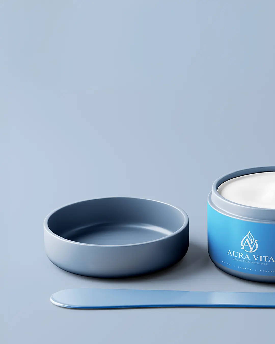 Un barattolo blu di crema Aura Vita è aperto, con il coperchio accanto e una spatola piatta blu davanti, il tutto su uno sfondo azzurro.